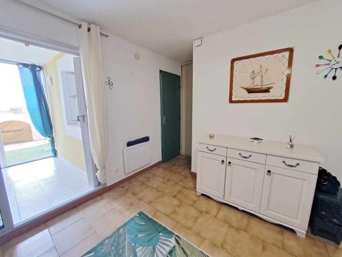 Cette grande chambre dispose d'une cuisine avec une grande fenêtre. dans l'établissement Appartement cosy 2 pièces - jardin privé, accès direct plage, animaux acceptés ! - FR-1-326-801, à Marseillan