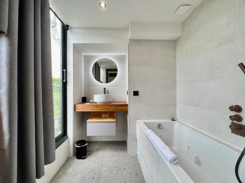 a bathroom with a tub and a sink and a mirror at Sea and mountain views from your Rooftop ! in Saint-Laurent-du-Var