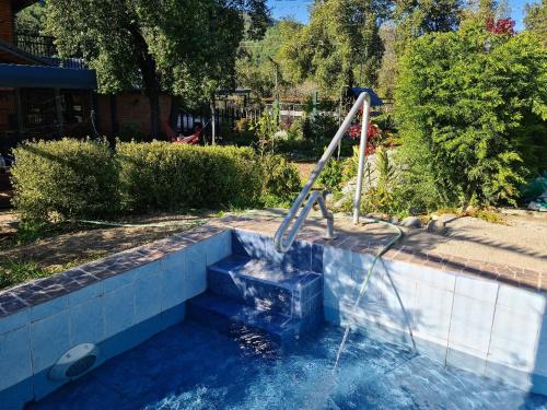 a water slide in a pool in a yard at Cabañas Abigail Ancoa Linares in Linares