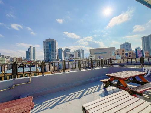 a picnic table on top of a building with a city skyline at Empathy Guesthouse in Daegu