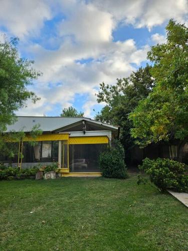 a house with yellow curtains on the front of a yard at Casa Quinta 2000 M² en centro de Francisco Álvarez in Francisco Álvarez