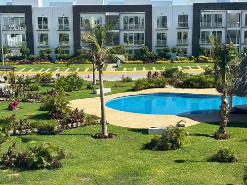 a resort with a pool and palm trees in front of a building at Departamento Boutique con más Amenidades que Ningún otro en la Zona in Acapulco