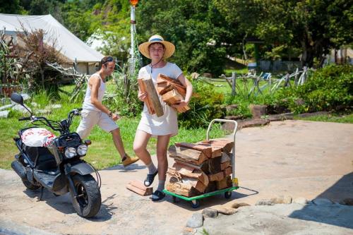 a woman standing next to a motorcycle with a cart of wood at Yamamizuki in Shimanto