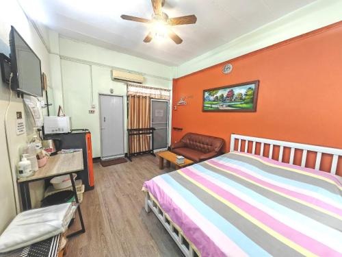a bedroom with a bed with an orange wall at The Backpacker stn in Nonthaburi