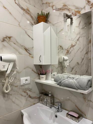ein Badezimmer mit einem Waschbecken und einer weißen Marmorwand in der Unterkunft Villa Dimo Topal in Ohrid