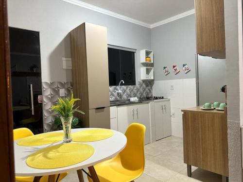 une cuisine avec une table blanche et des chaises jaunes dans l'établissement Apartamento mobiliado, à Porto Velho