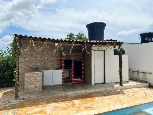 een klein bakstenen huis met een zwembad ervoor bij CASA FINCA PARA VACACIONAR in Turbaco