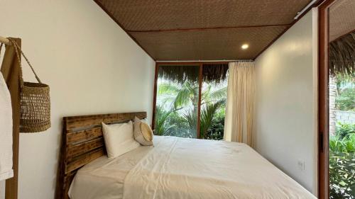 a bedroom with a bed and a large window at OLIVE Camping in Lagi
