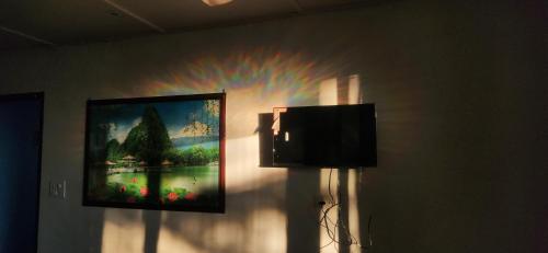 uma pintura de um arco-íris numa parede com uma televisão em On hills hotel em Mussoorie