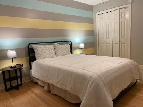 a bedroom with a bed with a striped wall at Guest house for group of 8 people in Charlottesville