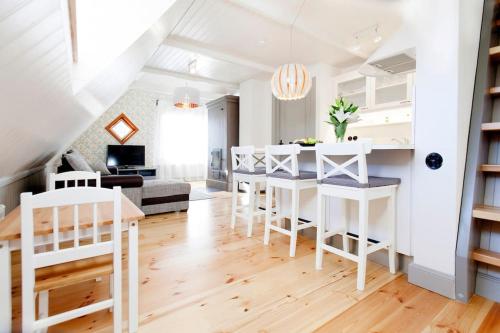 a white kitchen and living room with a table and chairs at Ösel Apartment - great for couples, friends and families in Kuressaare