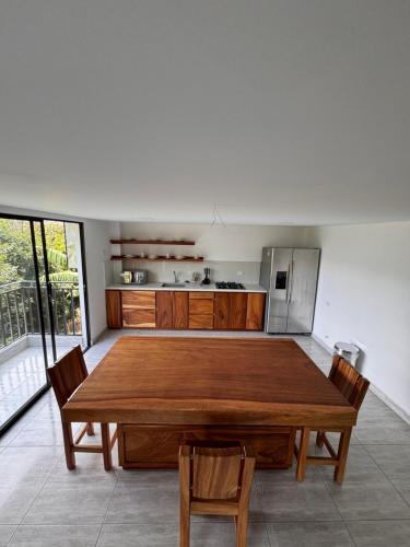 a kitchen with a large wooden table and chairs at Suite con Balcón Privado en Casa Campestre in Sabaneta
