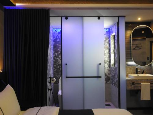 a room with a bed and a bathroom with a sink at B Hotel Kuala Lumpur in Kuala Lumpur