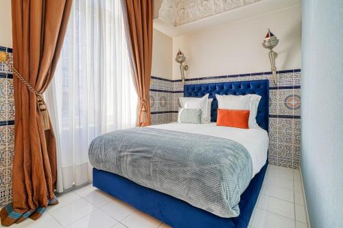 une chambre avec un lit bleu et une fenêtre dans l'établissement Marrakech Suite Champs Elysees, à Paris