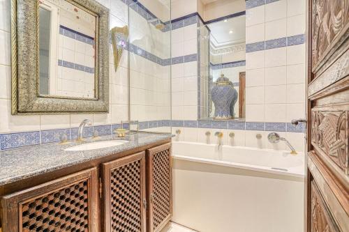 une salle de bain avec une baignoire et un lavabo et une baignoire dans l'établissement Marrakech Suite Champs Elysees, à Paris