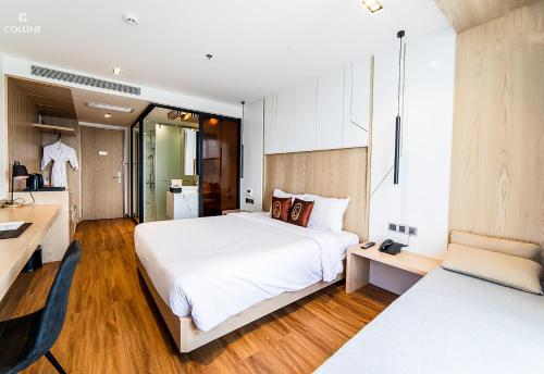 a bedroom with a large white bed and wooden floors at Colline Dalat in Da Lat