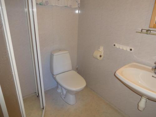 a white bathroom with a toilet and a sink at Maråk Hytteutleige in Geiranger