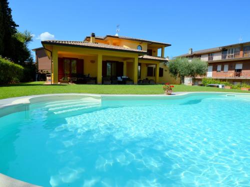 a swimming pool in front of a house at Pretty villa in Marsciano with nice garden and private pool in Marsciano