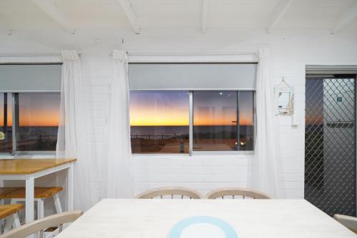 a dining room with a table and a window at Beachfront 3BR Home with Stunning Ocean Views in Quinns Rocks