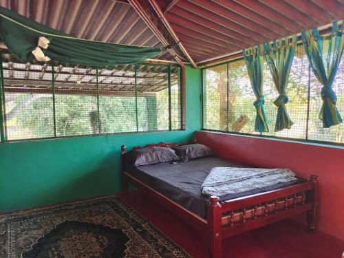 a bedroom with a bed in a room with windows at Ranjo's Farm house in Chāmrājnagar