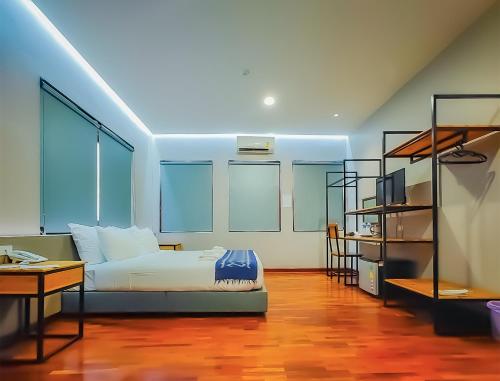 a bedroom with a bed and a desk and a shelf at The Riva Vientiane Hotel in Vientiane
