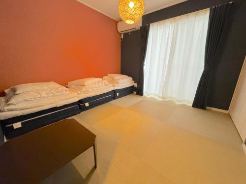 a room with two beds and a window at グランディオーソ沖縄ヴィラ恩納1 in Onna