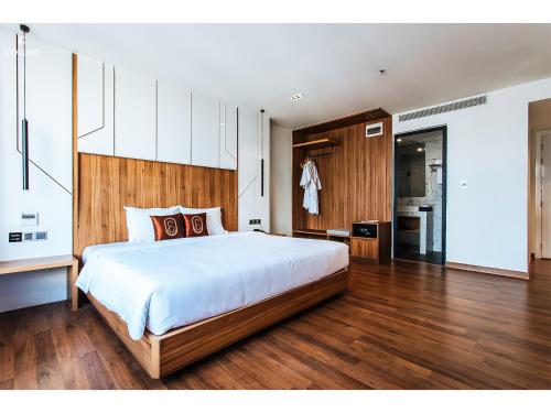 a bedroom with a large bed and a kitchen at Colline Dalat in Da Lat