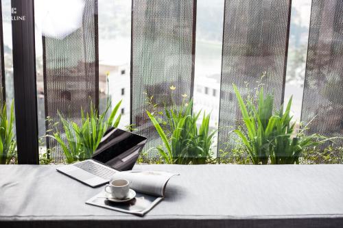 a table with a laptop and a cup of coffee at Colline Dalat in Da Lat