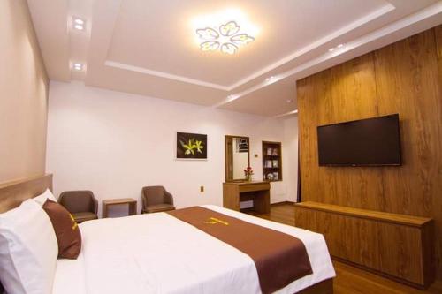 a hotel room with a bed and a flat screen tv at THU HOTEL in Ha Long