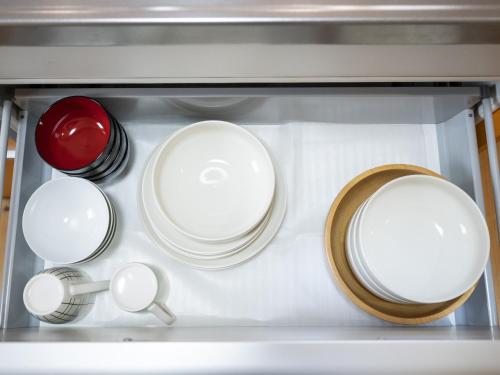 a group of plates and pans sitting in a refrigerator at Tabino Hotel Villa Miyakojima in Miyako Island