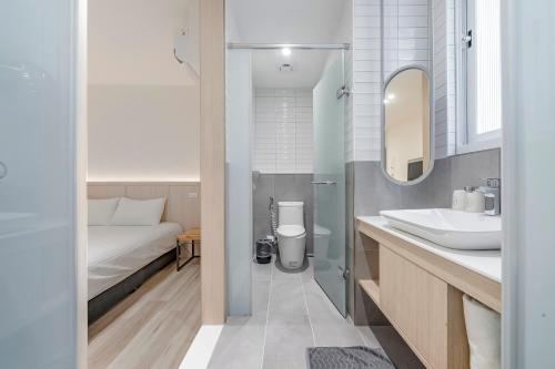 une salle de bain avec un lavabo et des toilettes et un lit dans l'établissement Taitung Spring Homestay B&B, à Taïtung