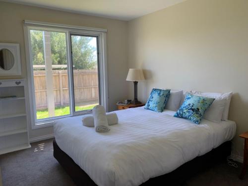 Schlafzimmer mit einem großen weißen Bett und einem Fenster in der Unterkunft Blue Vista in Port Fairy