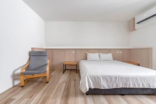 a bedroom with a bed and a chair at Taitung Spring Homestay B&B in Taitung City