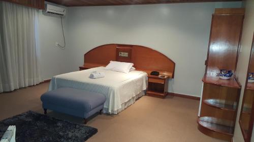 Habitación de hotel con cama y silla en Cristal Executive Hotel, en Francisco Beltrão