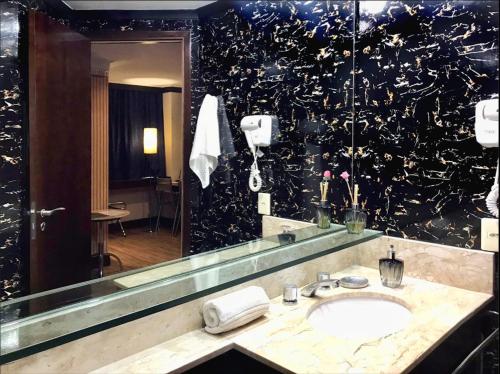 a bathroom with a sink and a large mirror at Flat na Paulista no Hotel Transamerica Particular in Sao Paulo