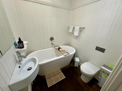 y baño con lavabo, bañera y aseo. en Barefoot Beach Cottage, en Geographe