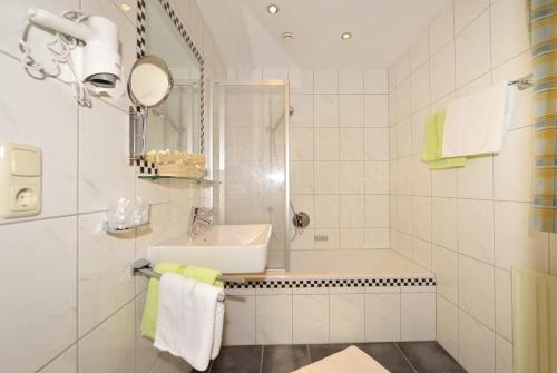 a white bathroom with a sink and a shower at Hotel Garni Viktoria in Sankt Anton am Arlberg