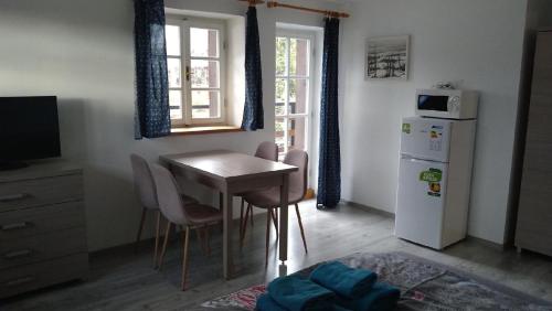 a kitchen with a table and chairs and a refrigerator at Rejviz apartmany in Zlaté Hory