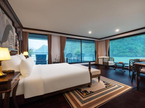 a bedroom with a large white bed and a living room at Era Premium Cruises Halong in Ha Long