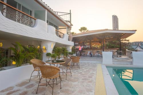 Windy Inn Hotel Pattaya في جنوب باتايا: فناء فيه كراسي وطاولة ومسبح