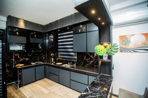 a kitchen with black cabinets and black counter tops at The Castle By Scenic Weligama in Weligama