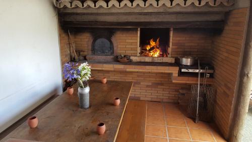 a brick oven with a table and a fireplace at Casa Franco in Ponta do Pargo
