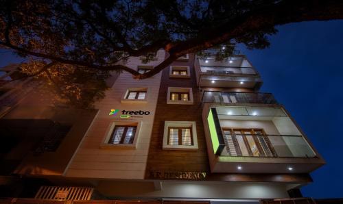 a tall building with a sign on it at night at Treebo Trend RR Residency - Sanjay Nagar in Bangalore