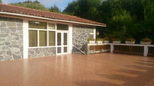 a house with a stone facade with a patio at Bungalows & Albergue La Playa in Logroño
