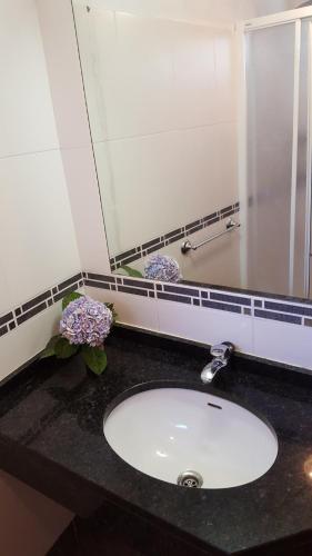 a bathroom counter with a sink and a mirror at Casa Franco in Ponta do Pargo