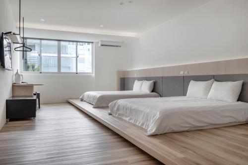 a bedroom with two beds and a desk in it at Taitung Spring Homestay B&B in Taitung City