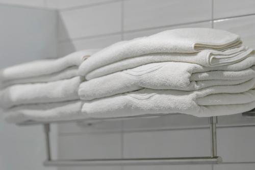 a stack of white towels on a rack in a bathroom at Taitung Spring Homestay B&B in Taitung City