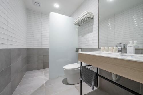 a white bathroom with a toilet and a sink at Taitung Spring Homestay B&B in Taitung City