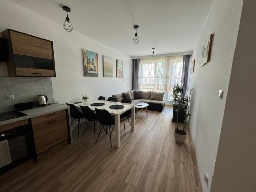 een keuken en een woonkamer met een tafel en een bank bij Kotlina Kłodzka - Apartament na Letniej in Kłodzko