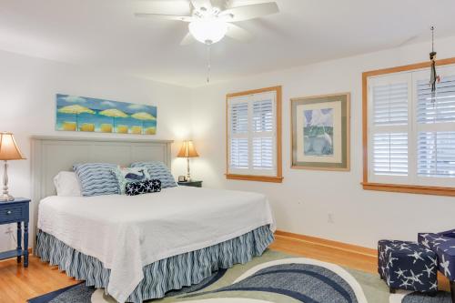 a bedroom with a bed and two windows at Courtyard Villas on Silver Lake in Ocracoke